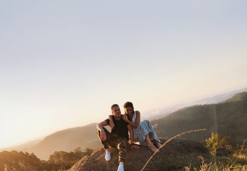 Junges Pärchen sitzt auf einem Stein